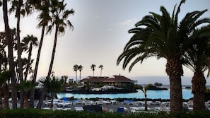 A resort with a pool area, palm trees, and a building with a red roof. - COSY STUDIO LA PINTA NEAR THE SEA AND THE MOUNTAINTS (Candelaria)