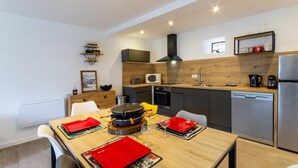 Una cocina moderna con comedor, equipada con estufa, microondas y lavavajillas.