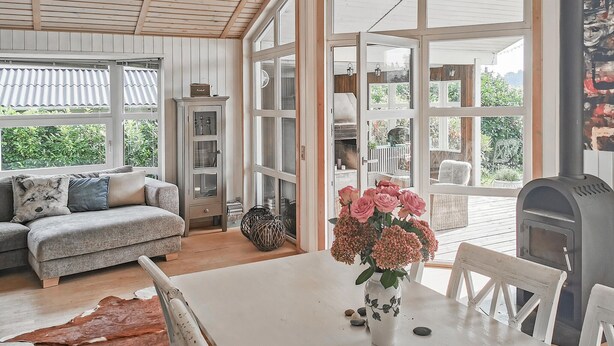 Ein gemütliches Wohnzimmer mit einer Couch, einem Tisch mit Blumen und einem Kamin.