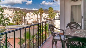 A balcony with a view of a residential area, featuring palm trees and a mountain in the background. - 2 bedroom cozy apartment in Almunecar (Almunecar)