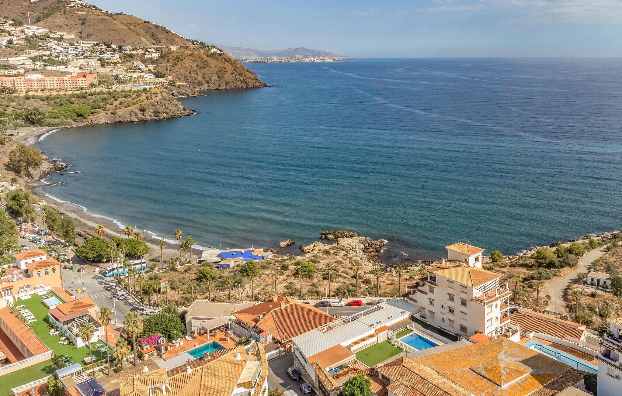 Un hotel frente al mar con varias construcciones, una piscina y vistas al océano.