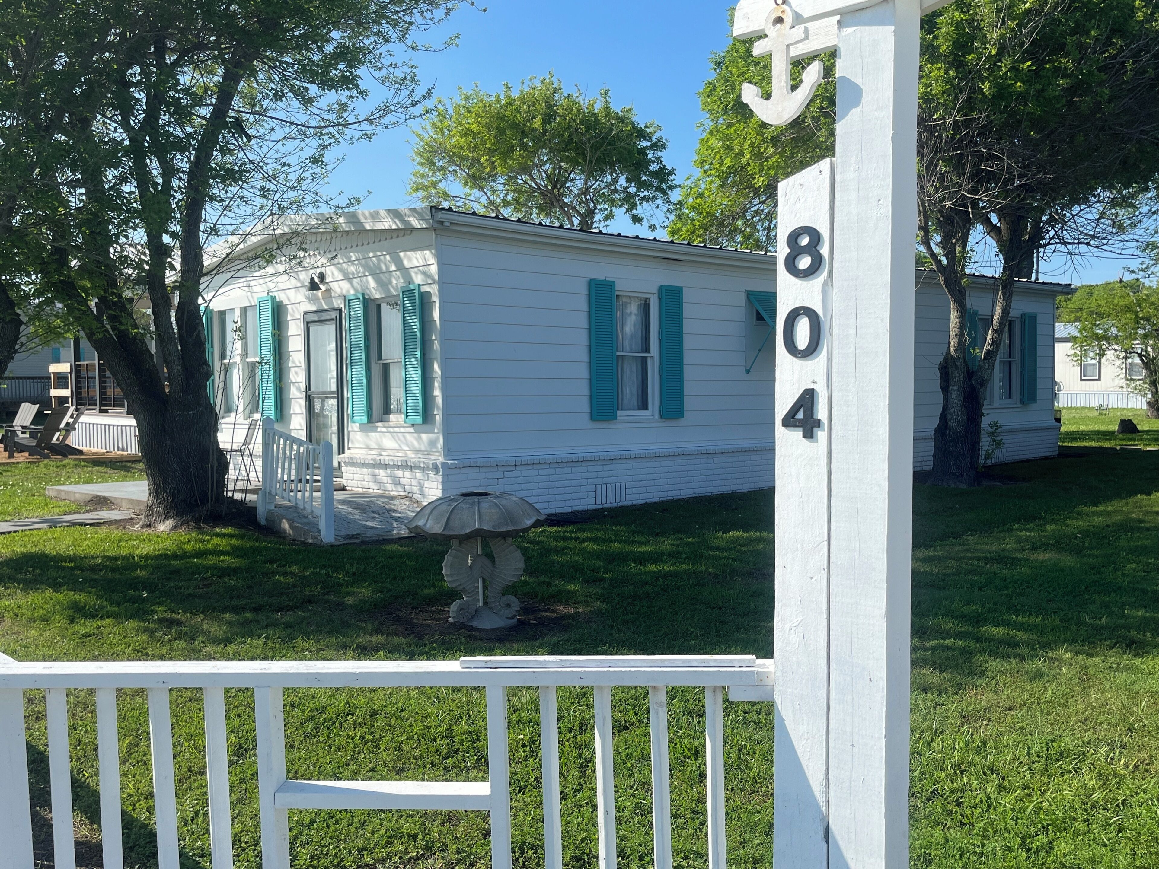 A white house with green shutters and a white picket fence.