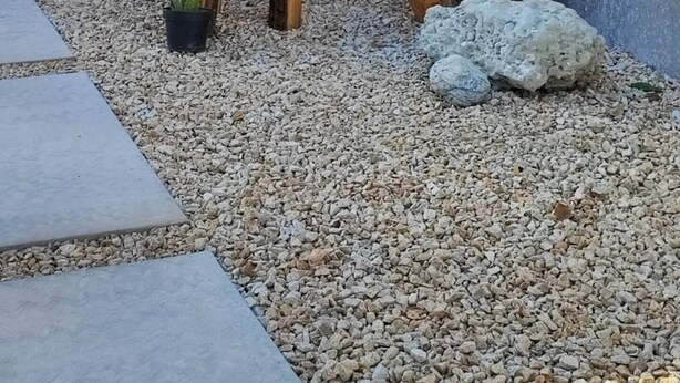 Un'area salotto esterna rustica con mobili in legno e una piccola pianta in vaso.