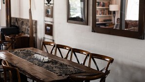 A dining area with a wooden table, chairs, and a decorative runner. - Jagungal 2 - Thredbo (Thredbo)