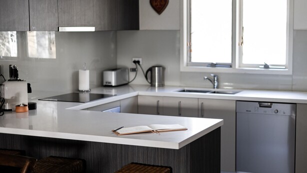 A modern kitchen with a central island, a dishwasher, and a window providing natural light. - Jagungal 2 - Thredbo (Thredbo)