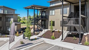 A modern apartment complex with multiple units, outdoor staircases, and landscaped gardens.