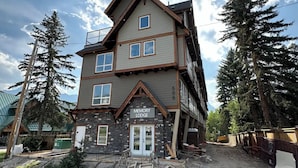 A multi-story lodge with a stone facade and a balcony on the upper floor.