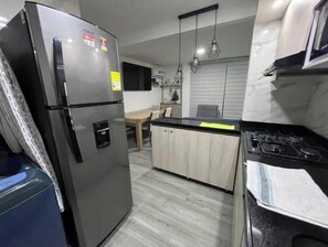 Microondas, cafetera y tetera, utensilios de cocina y comedor 