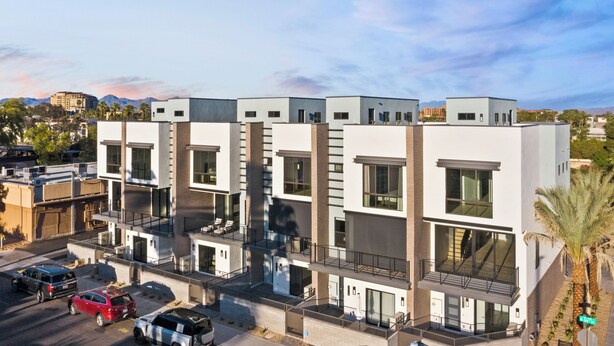 Un immeuble moderne à plusieurs étages, doté de balcons, de grandes fenêtres et d’un toit plat.