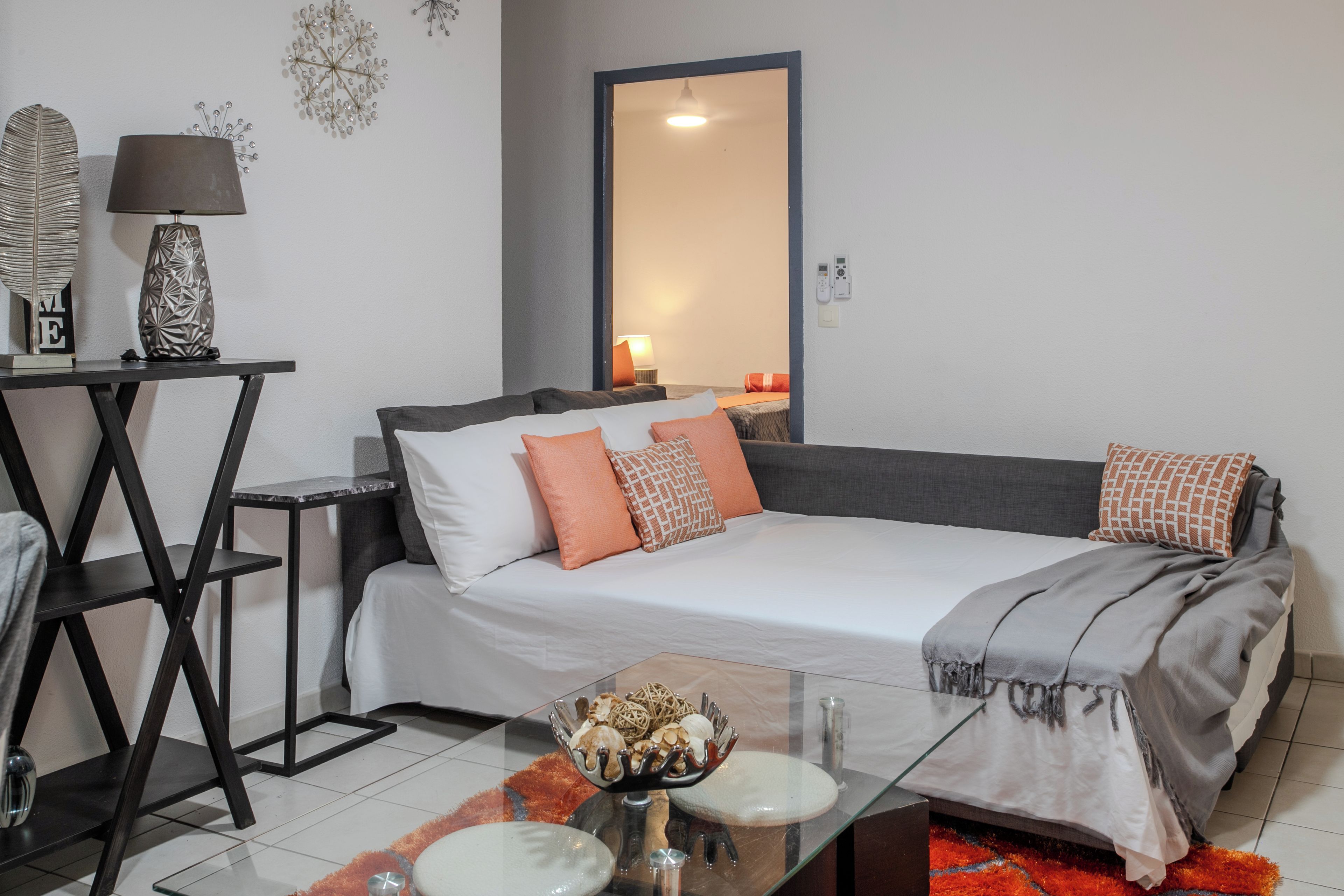 Une chambre à coucher moderne, comprenant un lit, une table de chevet, une lampe et des éléments décoratifs sur le mur.
