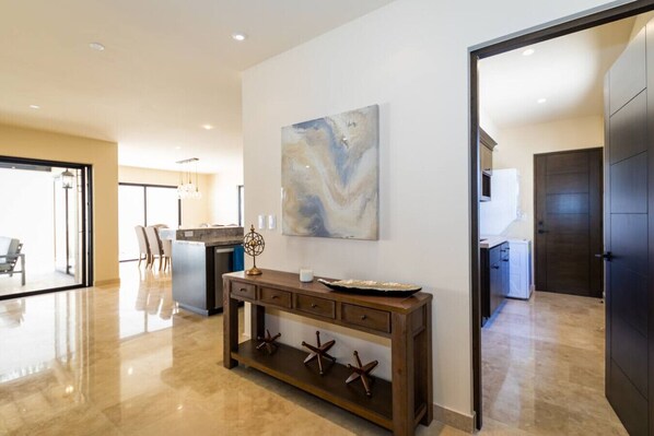 A spacious living area with a modern kitchen, a dining area, and a large window providing natural light.