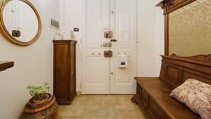 A room with a wooden bed, a mirror, a door with a lock, and a cabinet. - La Margherita by MMega (Coverciano)