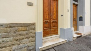 A building with a stone facade, a wooden double door, and a small set of steps leading to the entrance. - La Margherita by MMega (Coverciano)
