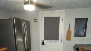 A kitchen with a stainless steel refrigerator, a wooden countertop, a patterned rug, and a door with a window. - Curve Cottage located on The Rattlesnake 192 just outside of Somerset.  (Somerset)
