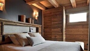 Un dormitorio con cabecera de madera, un ventanal grande y un cuadro enmarcado en la pared.