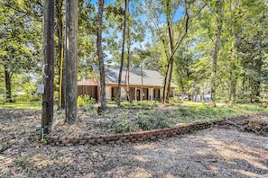 A building surrounded by trees with a gravel path and a brick border. - New Listing Promo + Cruising the Coast (Ocean Springs)