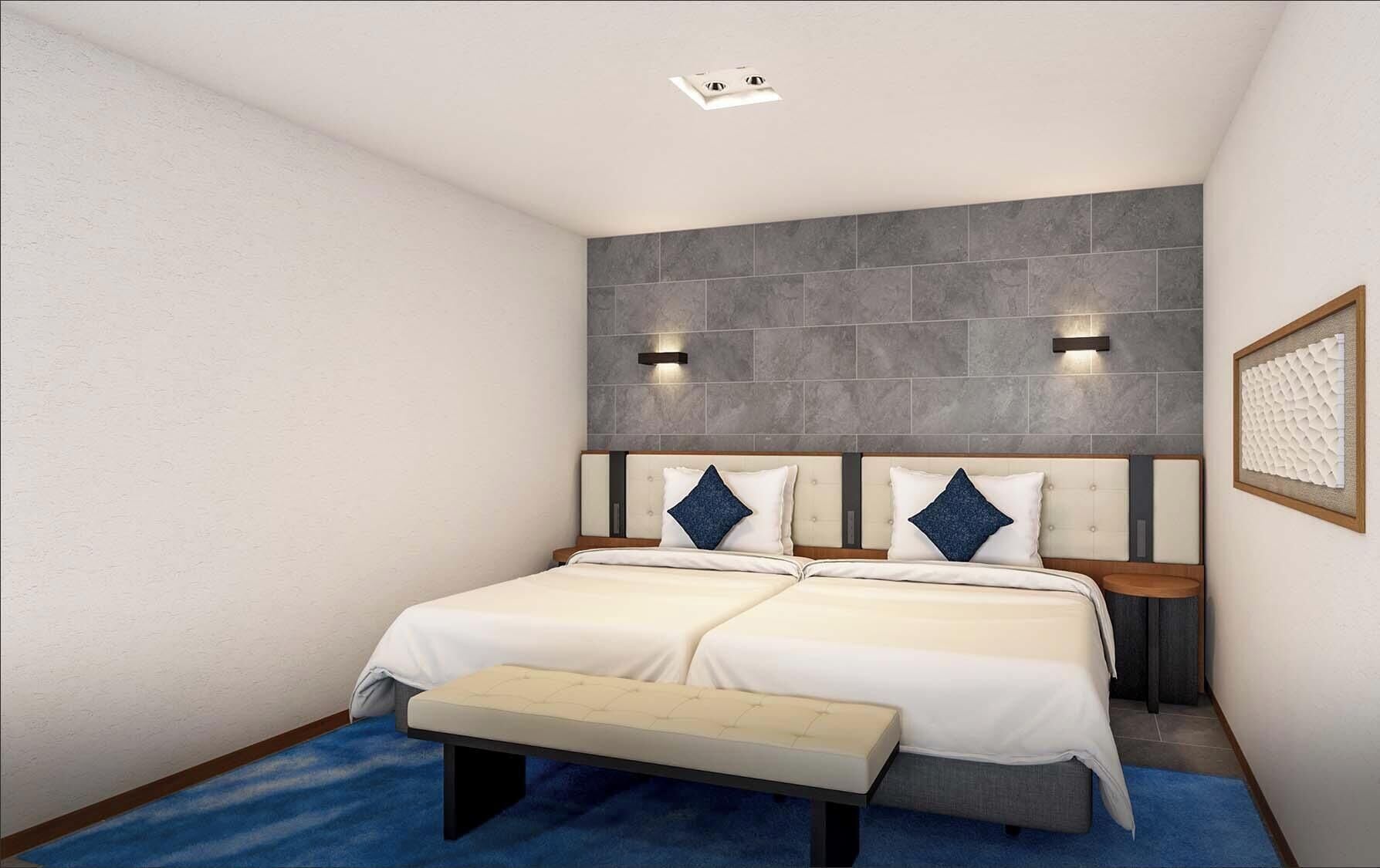 Un lit double avec une banquette, deux tables de chevet, une lampe fixée au mur et un panneau mural texturé.
