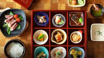 Una comida tradicional japonesa con diversos platos, incluyendo sushi, sashimi y arroz.