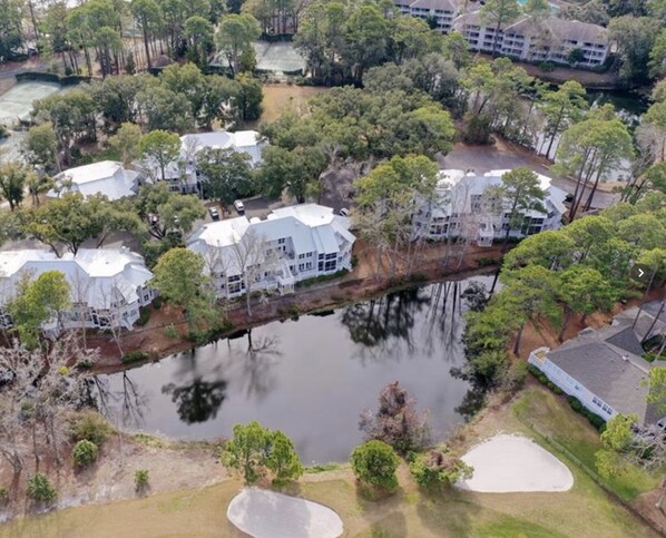 An aerial view of a residential area with multiple houses, a small lake, and a golf course. - HHI Villa with WestinResort amenities, PLUS golf tennis pickleball included (Hilton Head Island)