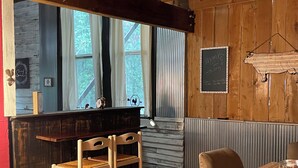 A rustic interior with wooden walls, a bar area, and a dining table.