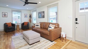 A living room with a brown sofa, two armchairs, a coffee table, a ceiling fan, and a door with a window. - Historic Cottage in Perry - 3 Bedroom 2 Bath (Perry)