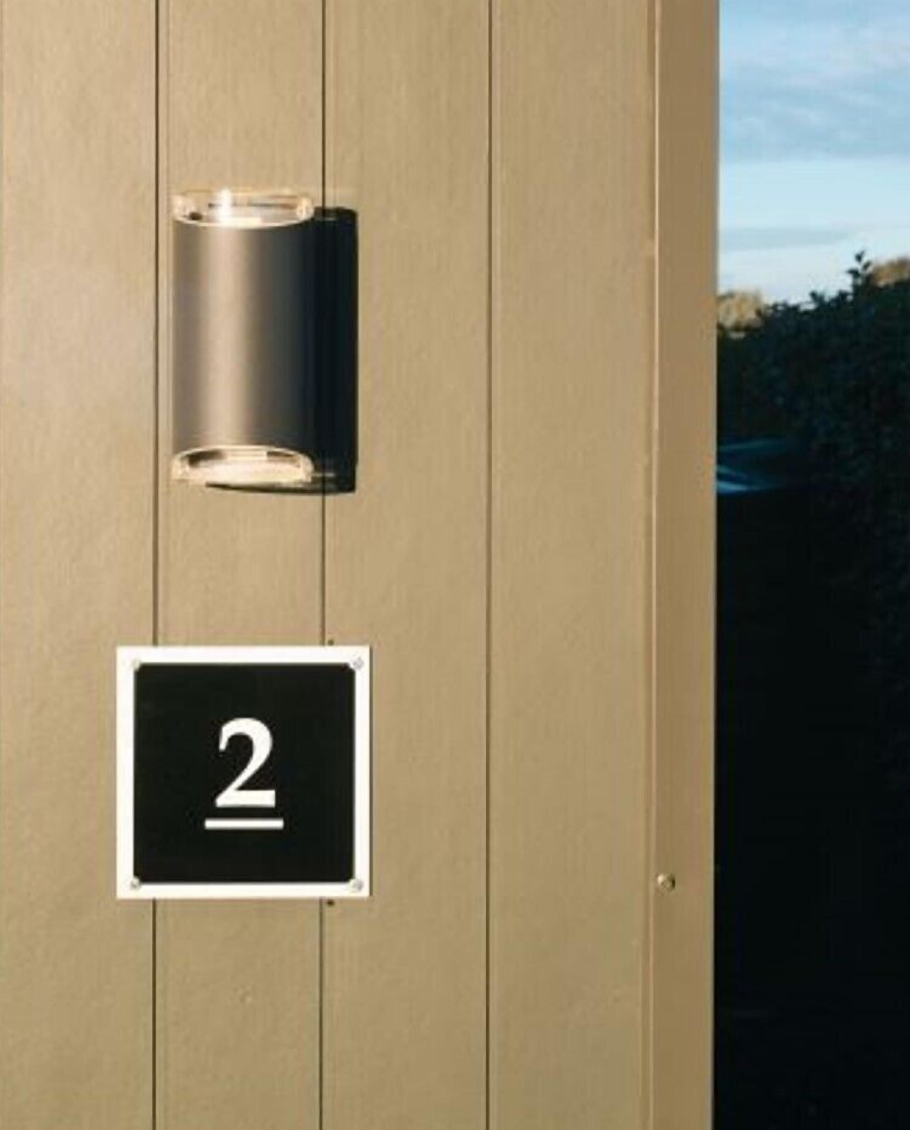 A door with a number '2' sign and a cylindrical light fixture.
