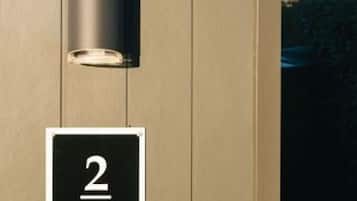 A door with a number '2' sign and a cylindrical light fixture.