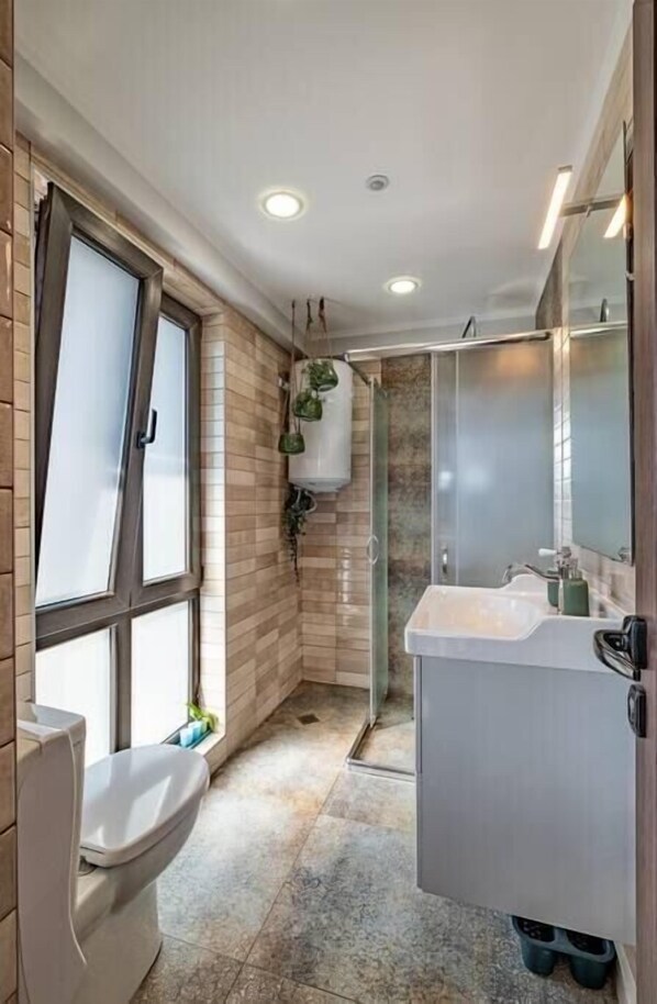 A modern bathroom with a toilet, sink, and shower.