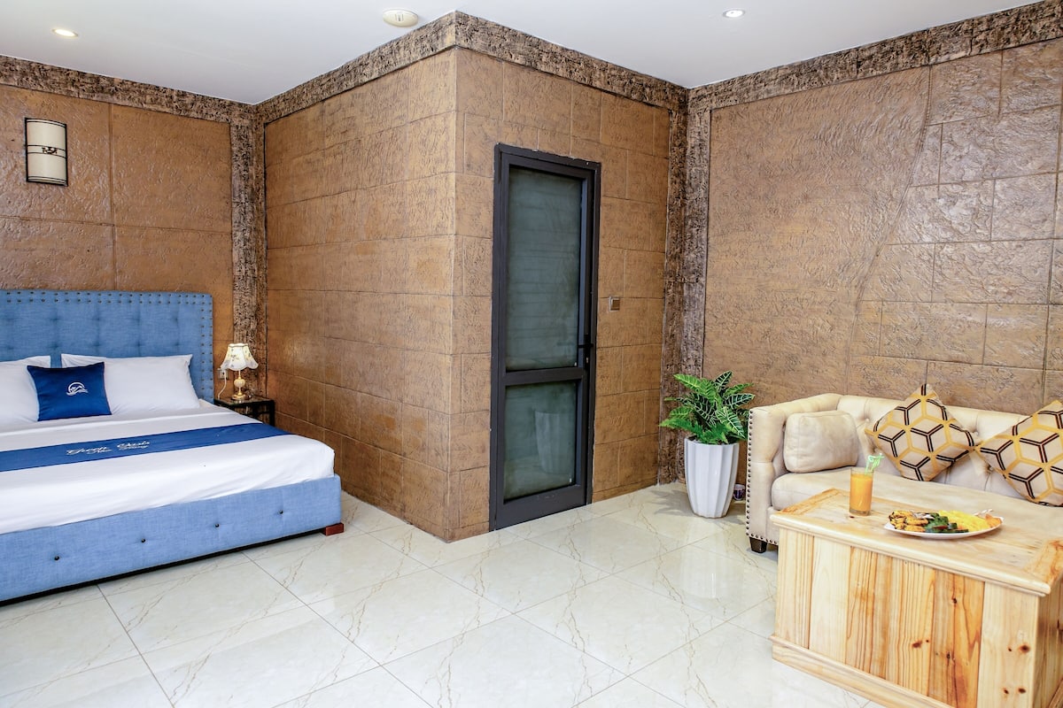 Een hotelkamer met een bed, een slaapbank, een koffietafel en een deur.