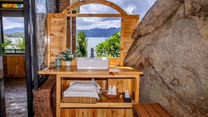 Uma sauna de madeira com uma janela grande, uma pia e um banco.