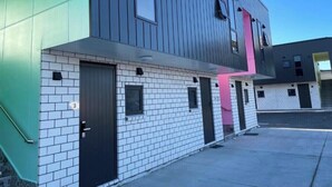 A modern building with a brick facade and a flat roof. - Krishna Motel (Papakura)