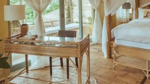A room with a bed, a table, and a window with curtains. - INARA Siargao (General Luna)