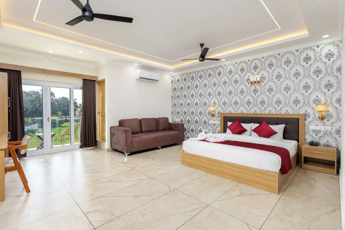 Une chambre moderne avec un grand lit, un canapé et un balcon agrémenté de rideaux.