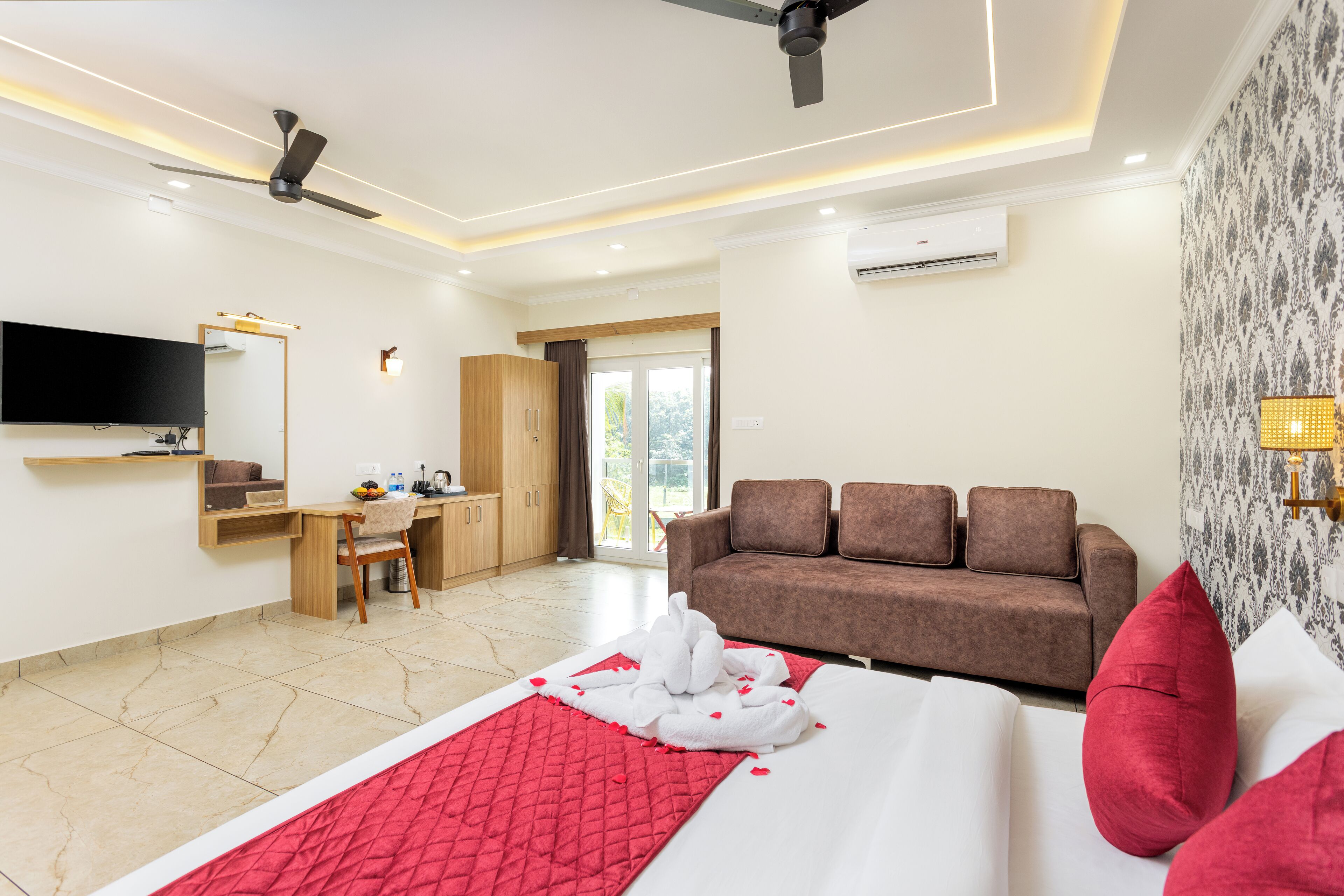 Une chambre d’hôtel équipée d’un lit, d’un bureau, d’un canapé, d’une télévision et d’un appareil de climatisation.