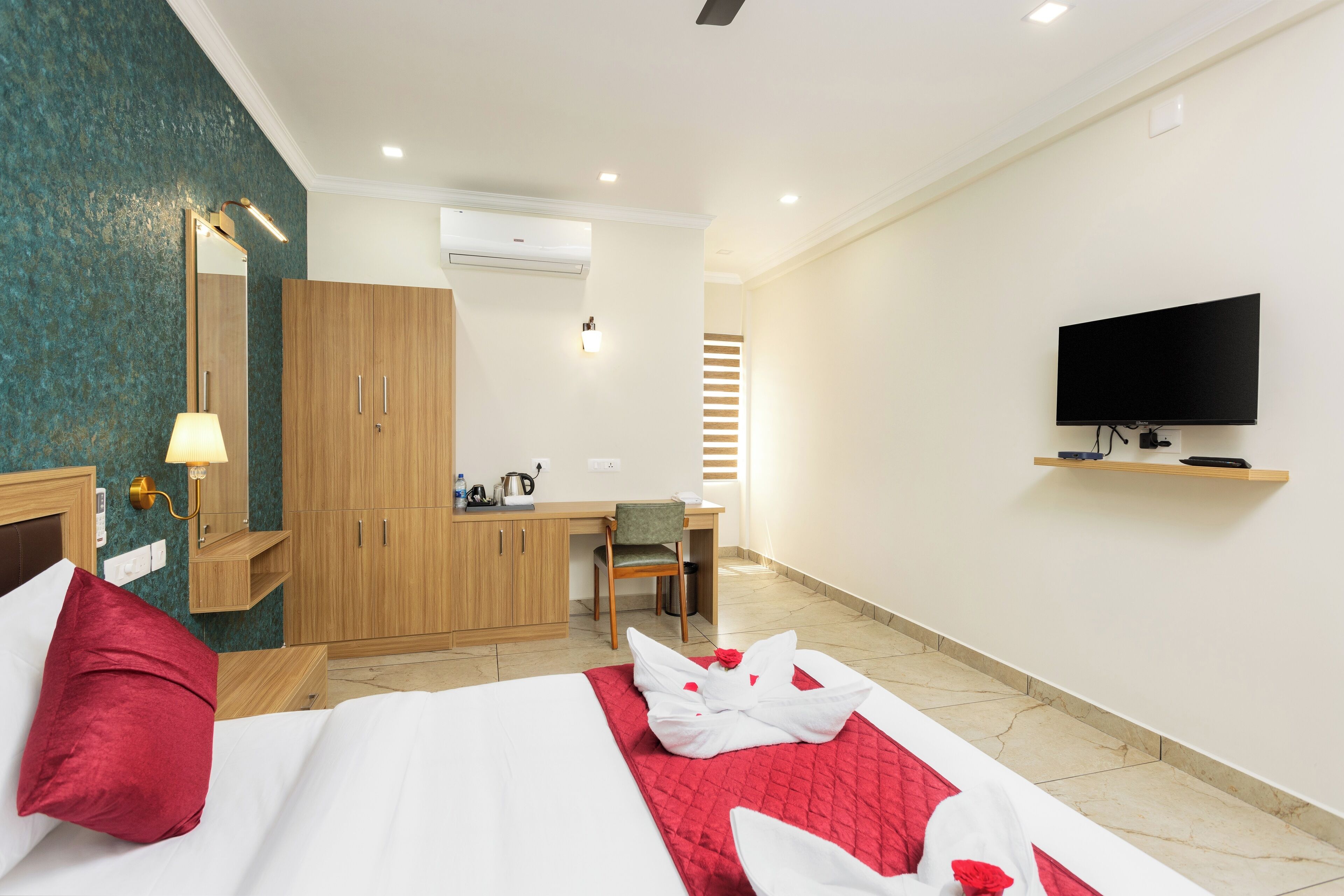 A hotel room with a bed, a desk, a television, and a wardrobe.