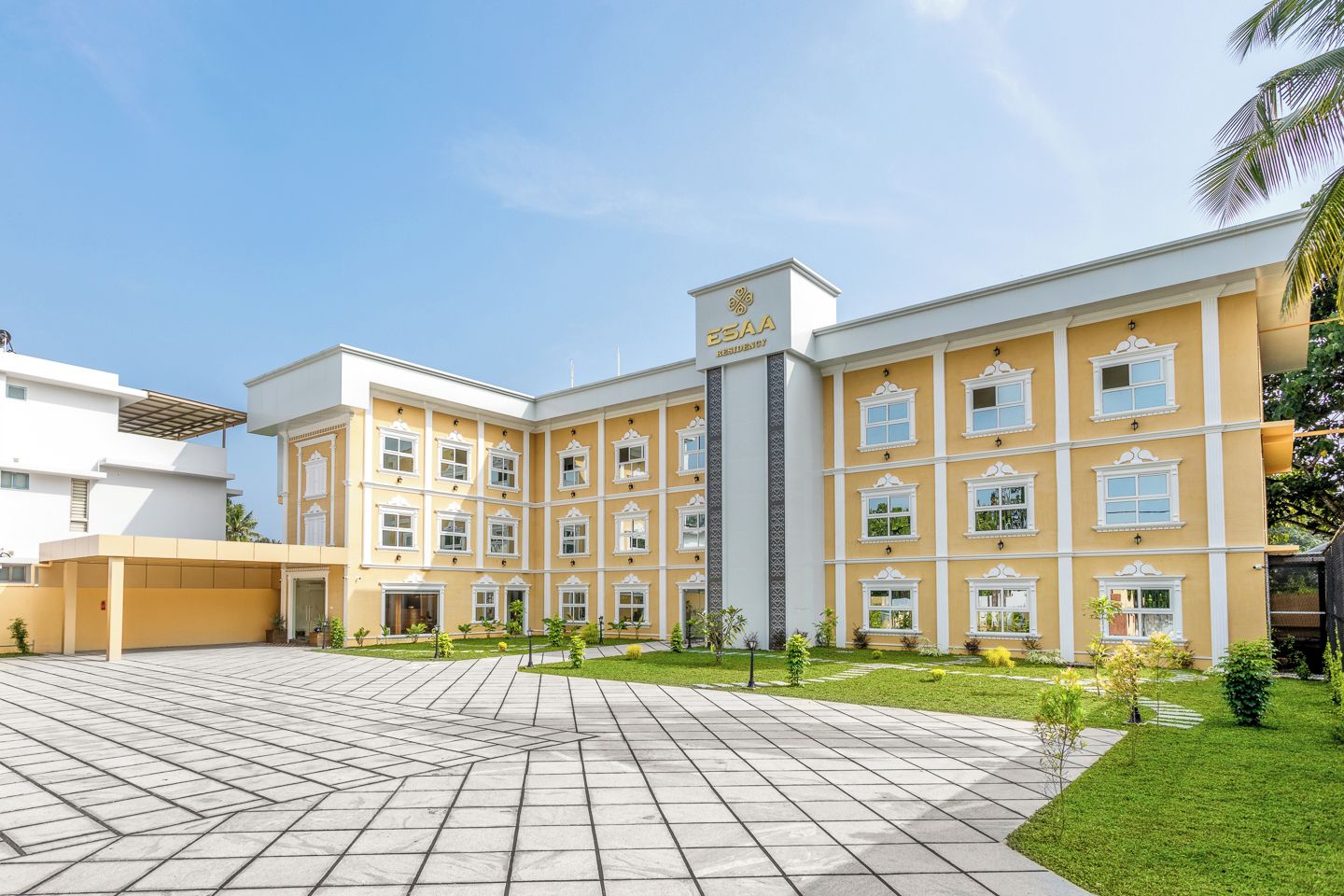 A hotel with a central courtyard, multiple windows, and a clear sky.