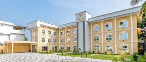 A hotel with a central courtyard, multiple windows, and a clear sky.