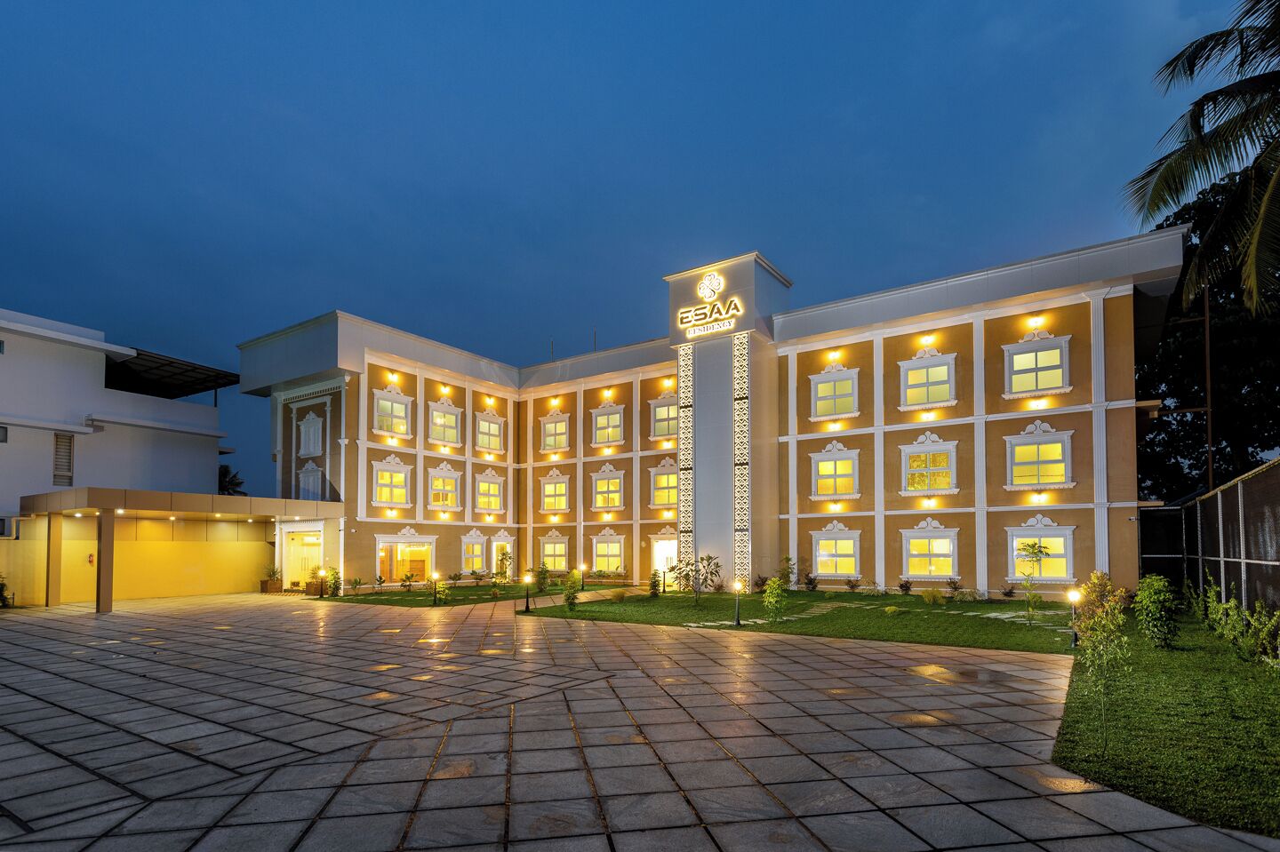 A hotel with a symmetrical facade, multiple windows, and a central entrance.