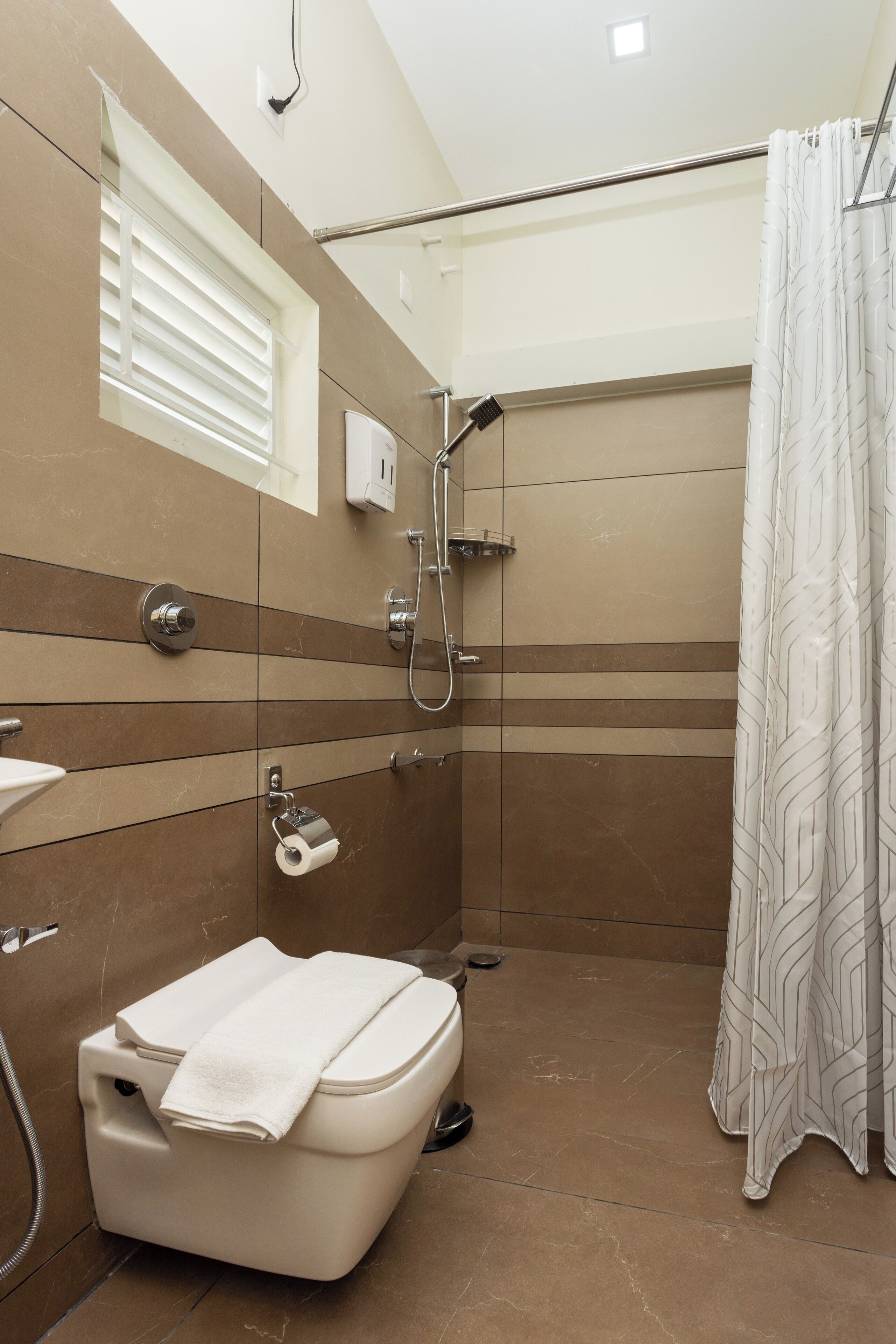 A bathroom with a shower, toilet, and towel rack.