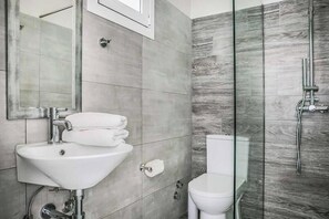 Une salle de bain moderne avec un lavabo, un miroir et une douche à parois en verre.