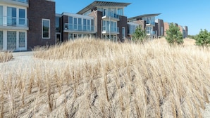 Een modern woongebouw met meerdere verdiepingen, grote ramen en een plat dak.