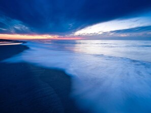 A beach with a calm sea and a sunset sky. - Detached Holiday Bungalow With Garden (Callantsoog)