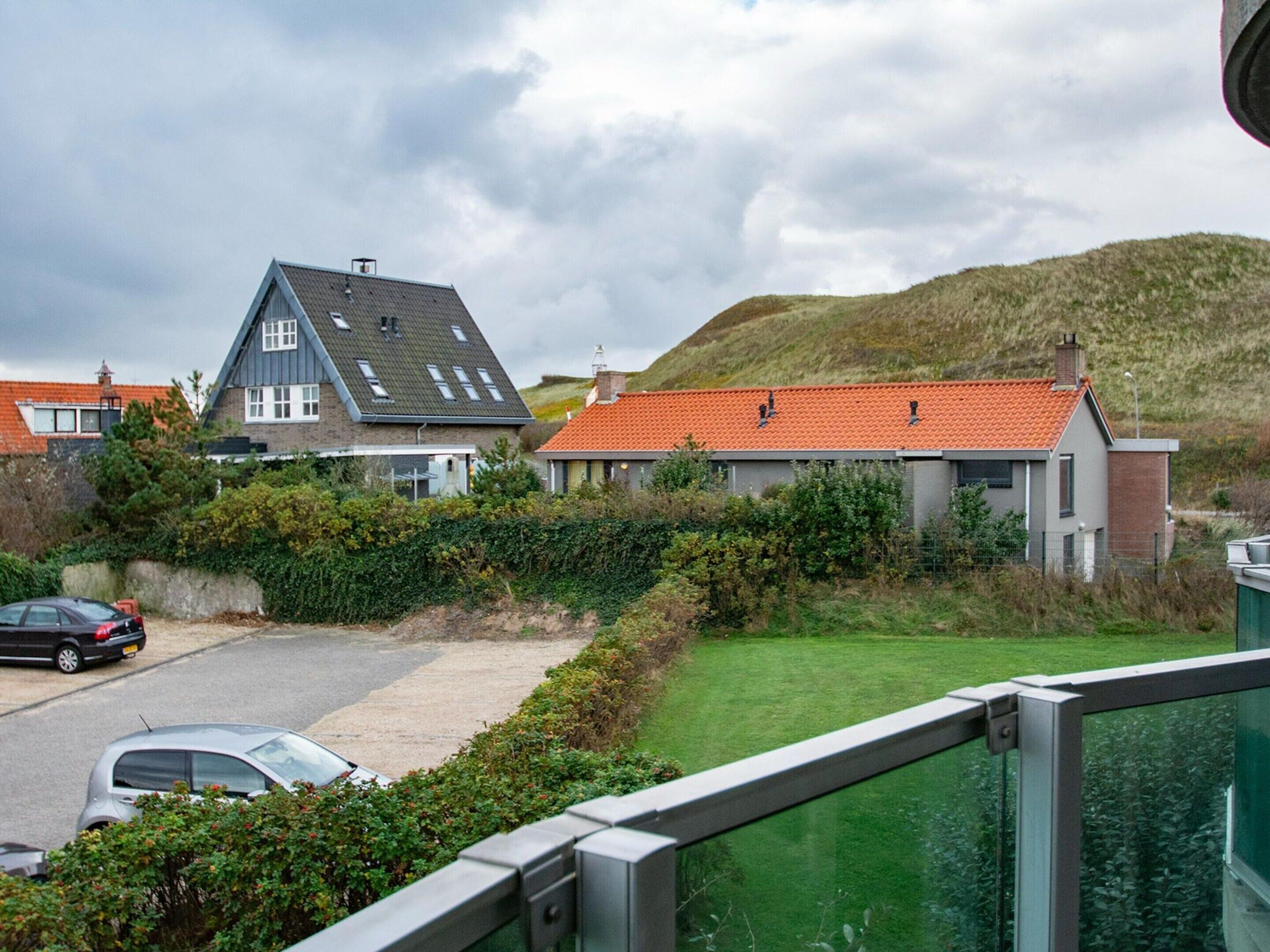 A residential area with houses, a parking lot, and a grassy area.