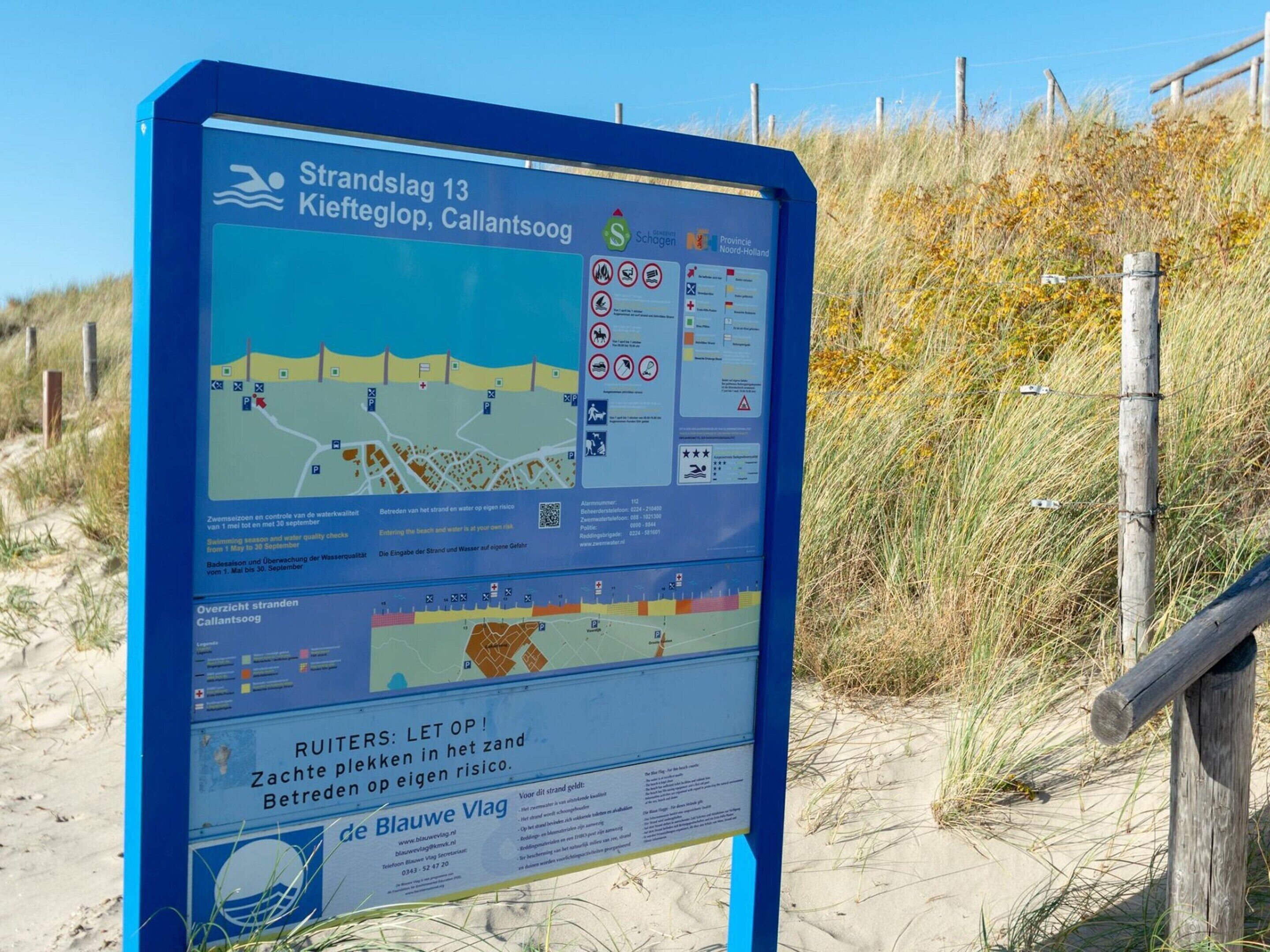 Ein Hinweisschild am Strand mit Karten und Sicherheitshinweisen.