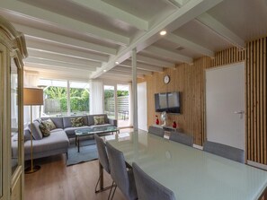 A modern living room with a sofa, coffee table, and dining area.