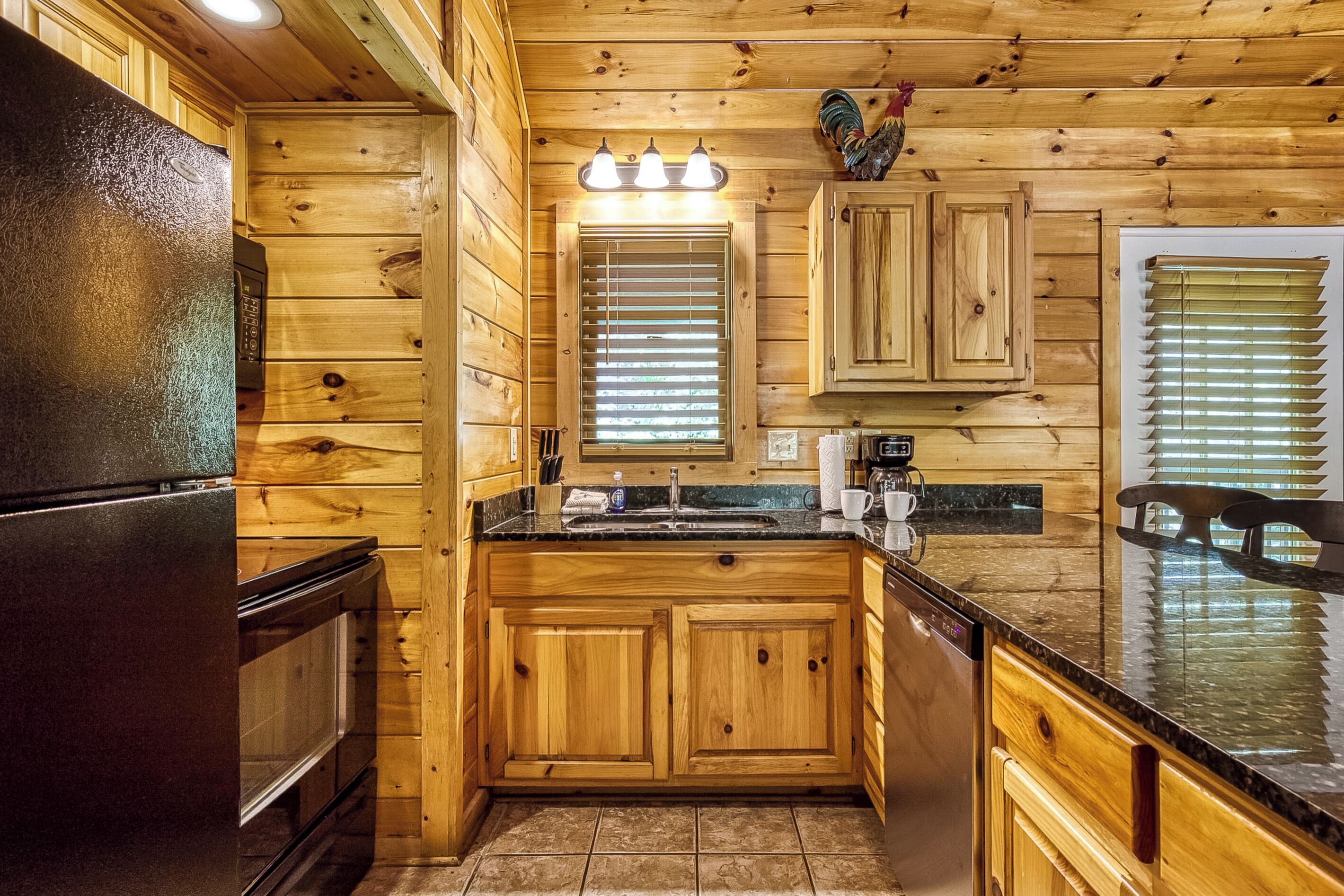 Un interior de madera con una zona de cocina, que incluye un refrigerador, un lavamanos y armarios.