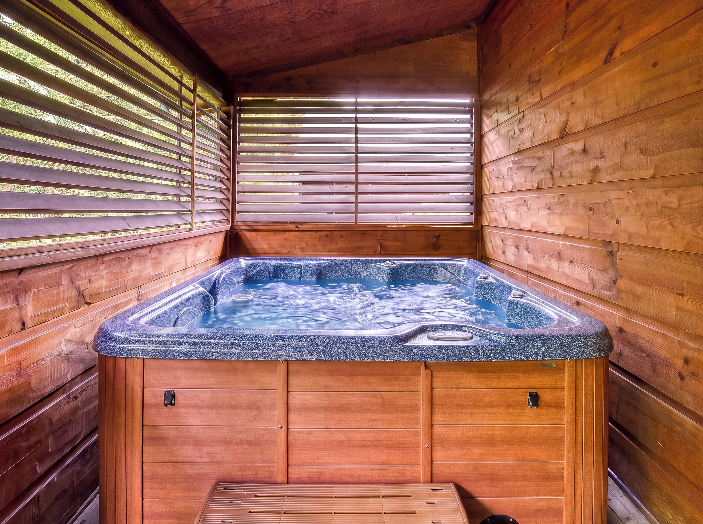 Une cabane en bois dotée d’un bain à remous, de murs en bois et d’une fenêtre avec des stores.