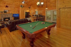 A cozy room with a pool table, a leather sofa, a fireplace, and a television. - New Listing! 2 Minutes from Pigeon Forge Parkway! Hot tub/Pool table/Romantic! (Pigeon Forge)