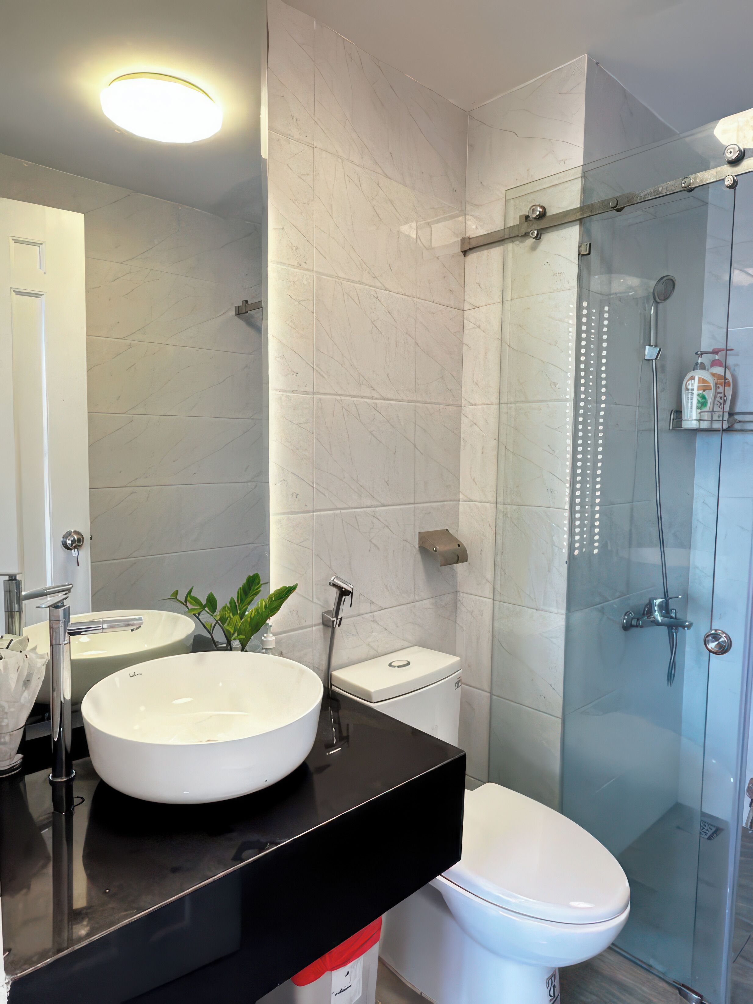 Ein modernes Badezimmer mit einem weißen Waschbecken, einer Toilette und einer Duschkabine.