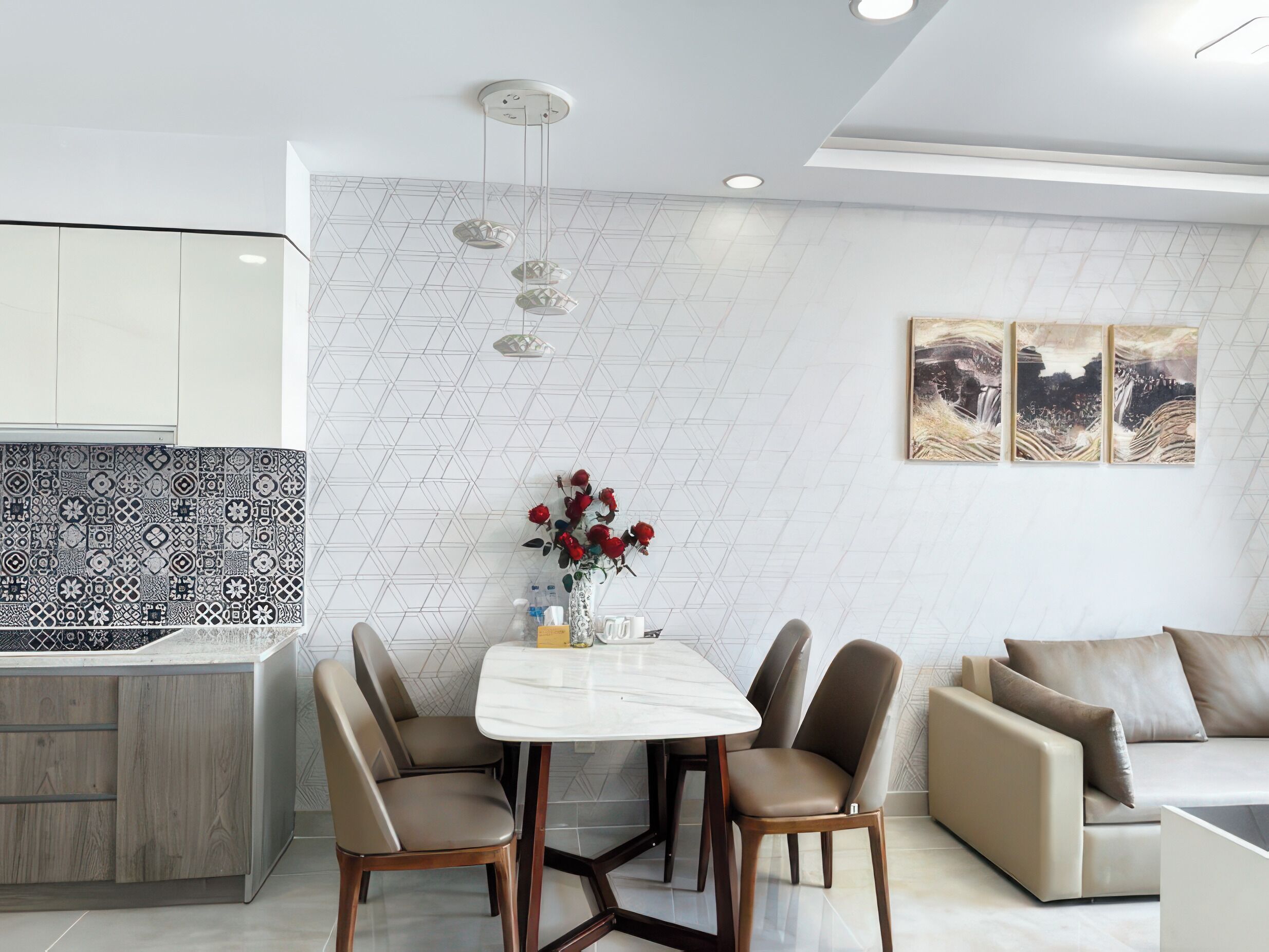 A modern kitchen with a white tiled backsplash, a dining table with chairs, and a sofa.